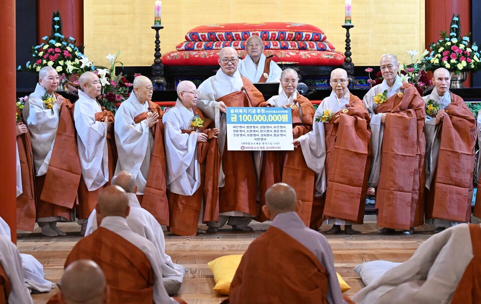 명사 법계 품서를 받은 스님들이 승려복지기금을 전달하고 있다.