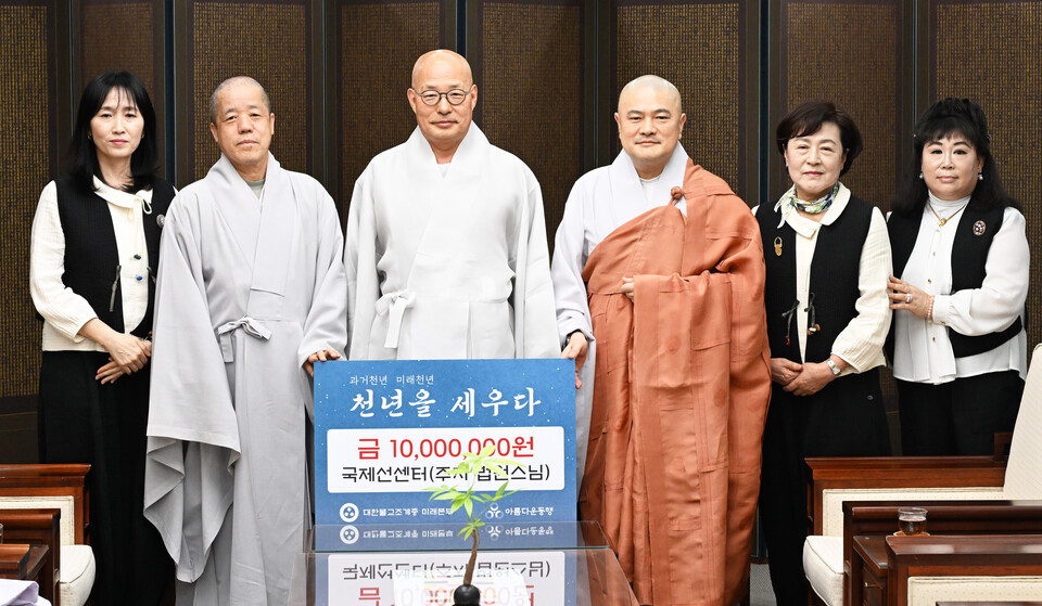 총무원장 진우스님과 미래본부 불교사회연구소장 원철스님, 서울 국제선센터 주지 법원스님과 신도들이 '천년을 세우다' 기금 전달식 뒤 기념촬영을 하고 있다.  