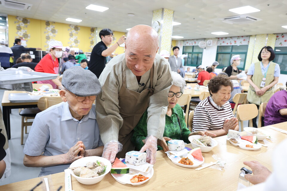 생명나눔실천본부가 본격적인 무더위 시작을 알리는 초복을 맞아 어르신들의 건강한 여름나기를 기원하며 자비행을 베풀었다. 사진은 생명나눔실천본부 이사장 일면스님이 송산노인종합복지관 이용자 어르신에게 여름 보양식을 대접하는 모습.