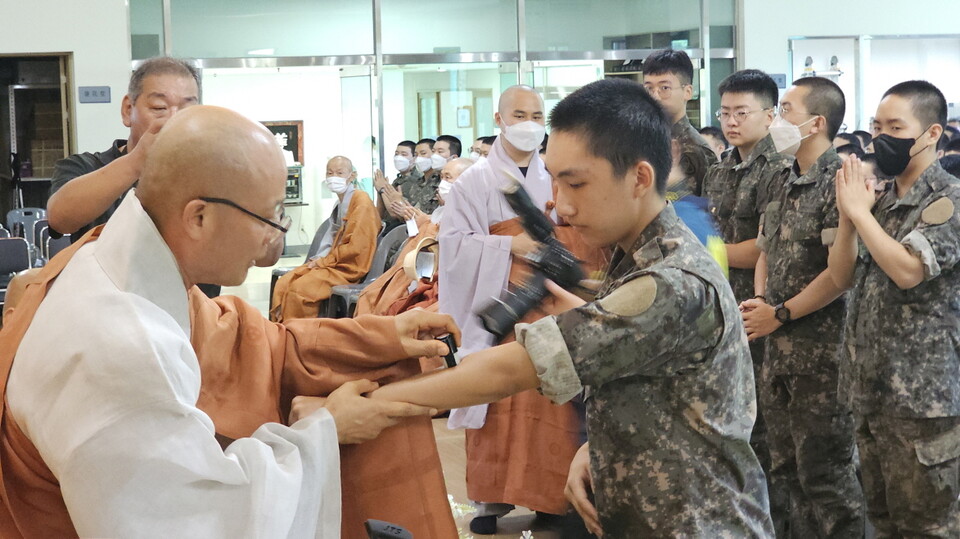 전계사 선운사 주지 경우스님이 한 병사에게 연비를 하고 있다.