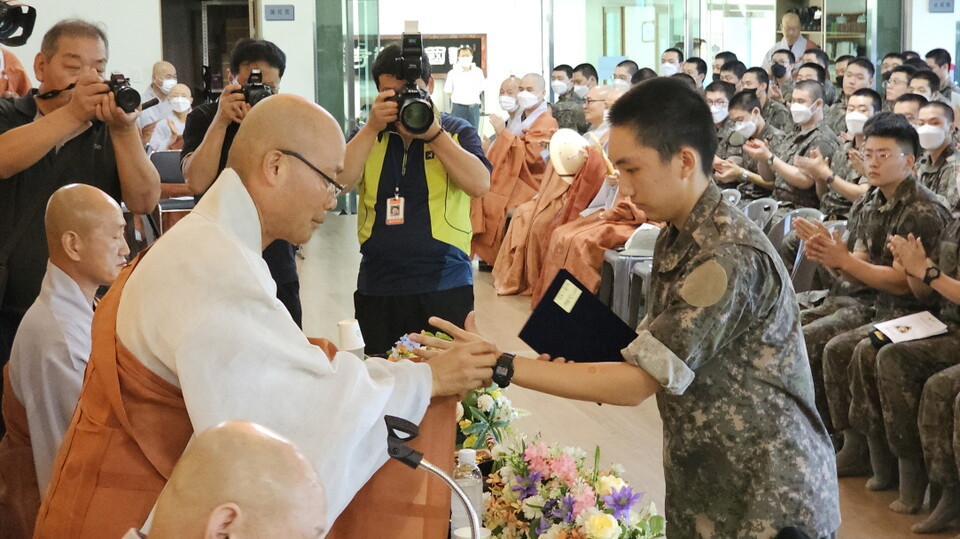 전계사 경우스님이 대표 수계병사에게 수계증과 단주를 수여하고 있다.