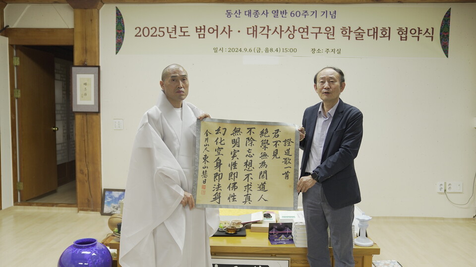 범어사 주지 정오스님이 동산대종사 친필 증도가를 김광식 교수에게 설명하고 기념사진을 찍고 있다.