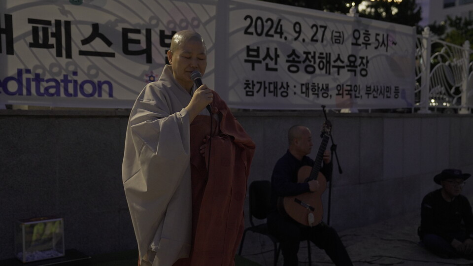 주석스님이 기타에 맞춰 명상을 지도하고 있다.