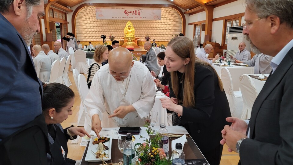 사찰음식 명장 대안스님이 주한 외국인 대사와 외교관 및 가족에게 사찰음식에 대해 설명하고 있다.