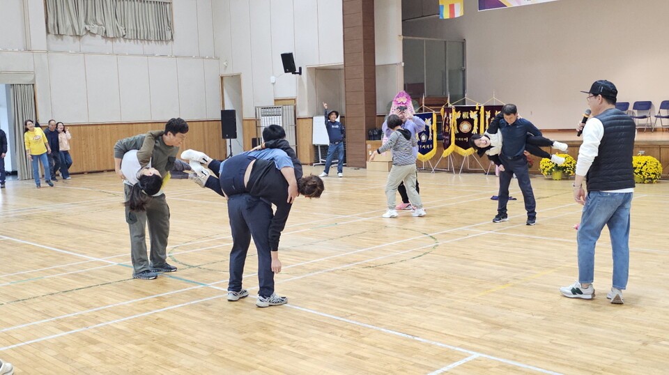 남자가 여자를 업었다가 자세를 바꾸며 오래 견디는 게임을 하고 있다.