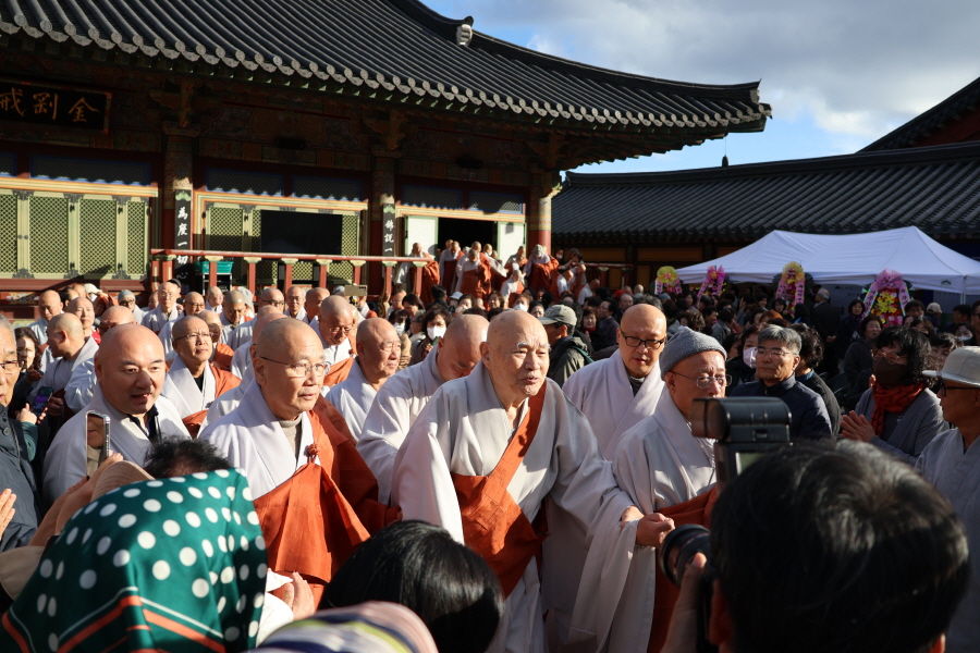 기념 촬영을 위해 법당을 나서는 무비스님을 대중이 에워싸고 있다.