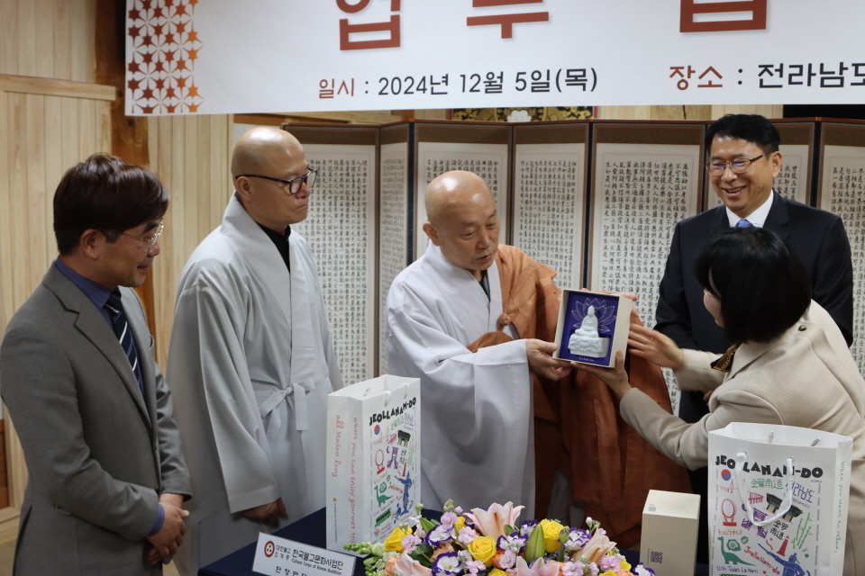 단장 만당스님과 김영신 대표이사가 서로 기념품을 주고 받았다.