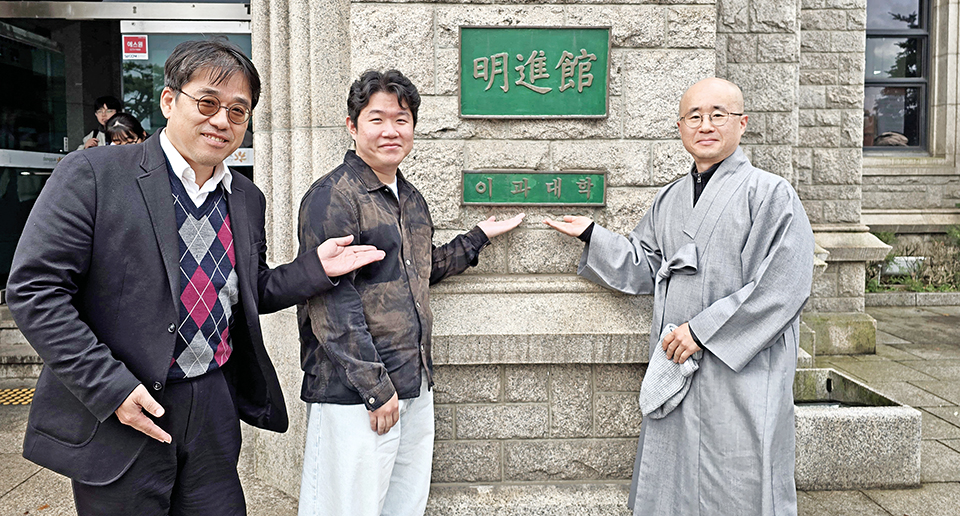 동국대학교 불교동아리 자연과함께 권기운 지도교수, 김준범 회장, 지도법사 일윤스님이 명진관 이과대학 명패를 가리키며 불교동아리 가입을 권유하고 있다.