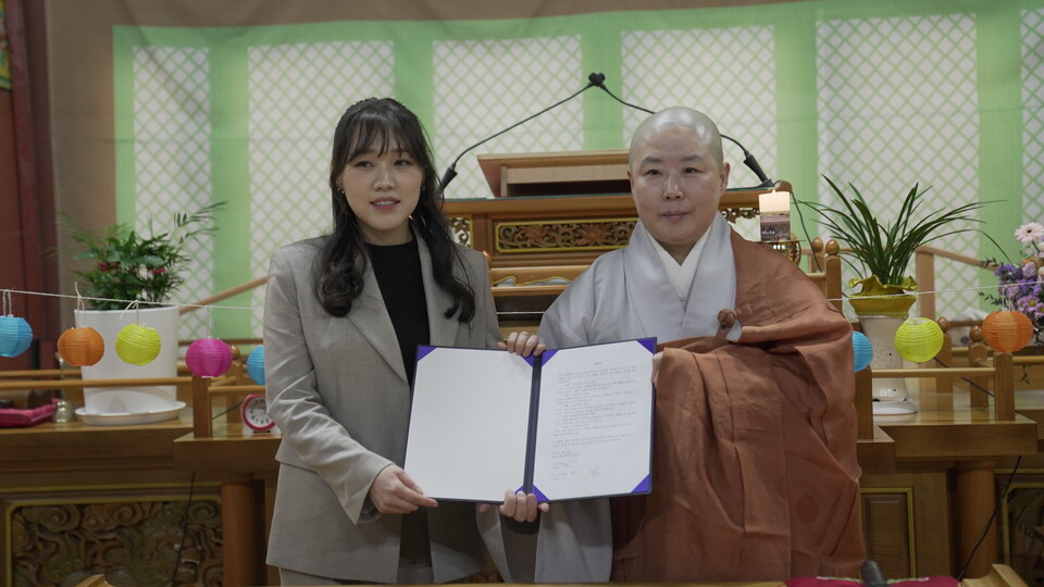 서약서 작성후 기념사진을 찍고 있는 지도법사 법진스님과 서영란 회장.