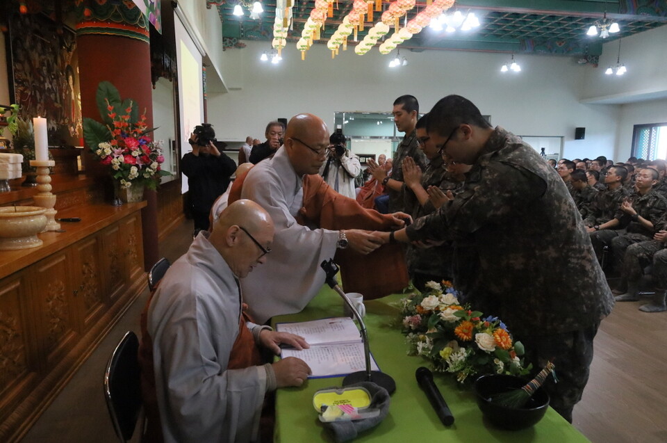 전계사 경우스님이 대표병사들에게 연비를 하고 있다.