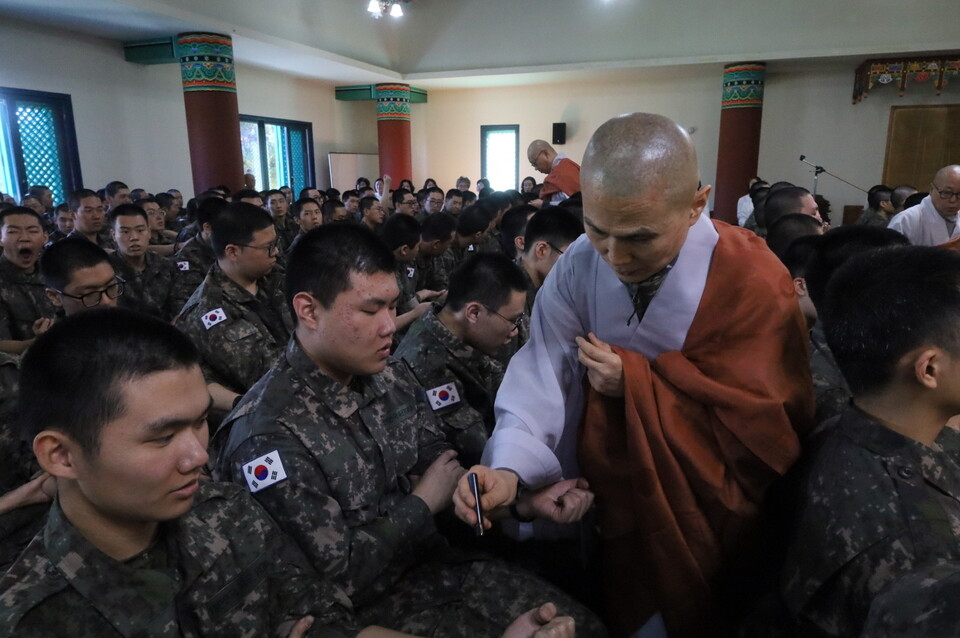 스님들이 병사들 좌석 통로를 다니며 연비를 하고 있다.