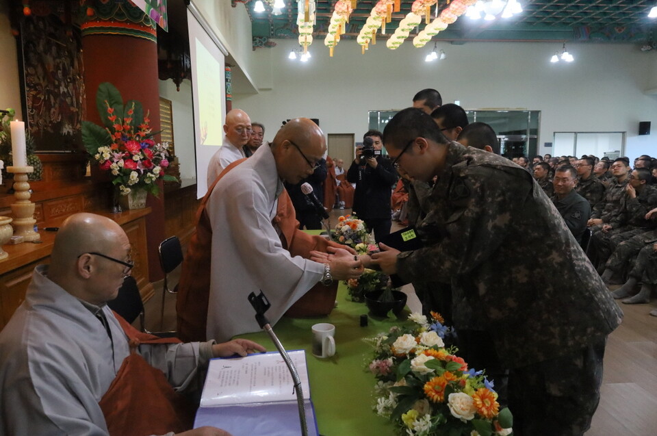 전계사 경우스님이 대표병사들에게 수계증과 단주를 수여하고 있다.