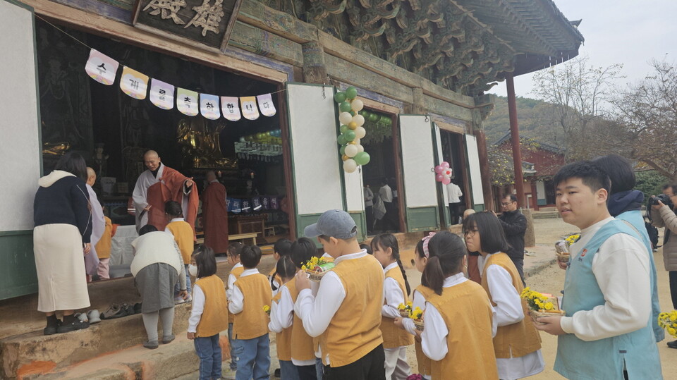 이날의 수계제자들이 줄을 지어 공양물을 들고 법당으로 입장하고 있다.