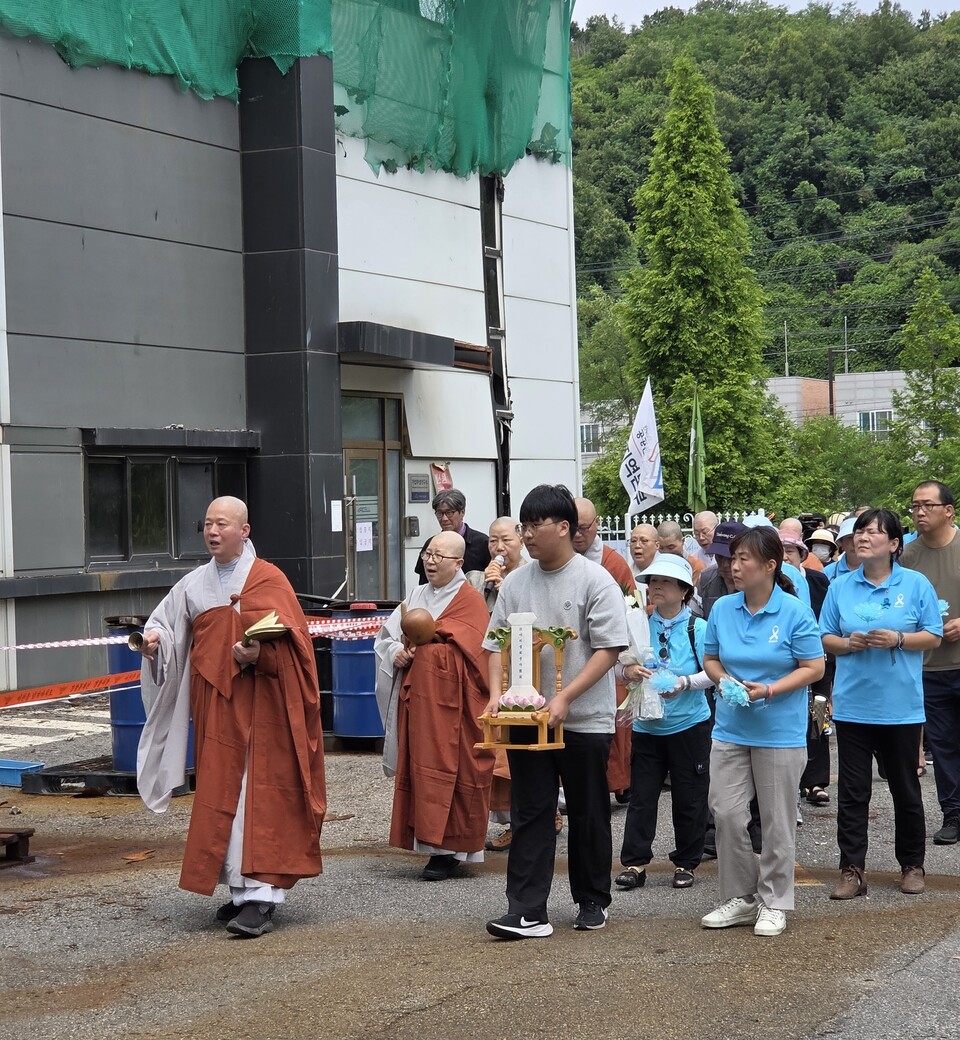 사노위 스님들이 아리셀 공장 화재 참사 희생자 위패를 들고 화재 현장으로 이동해 위패 소전 의식을 진행하는 모습.