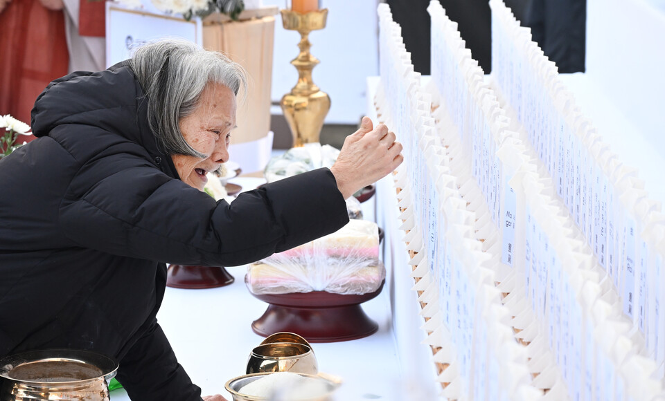 위패를 어루만지며 통곡하는 한 유가족.