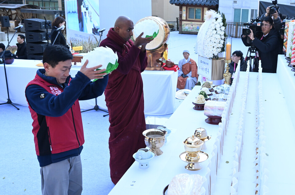 우다야라이 이주노조 위원장과 외국스님이 헌등을 하고 있다.