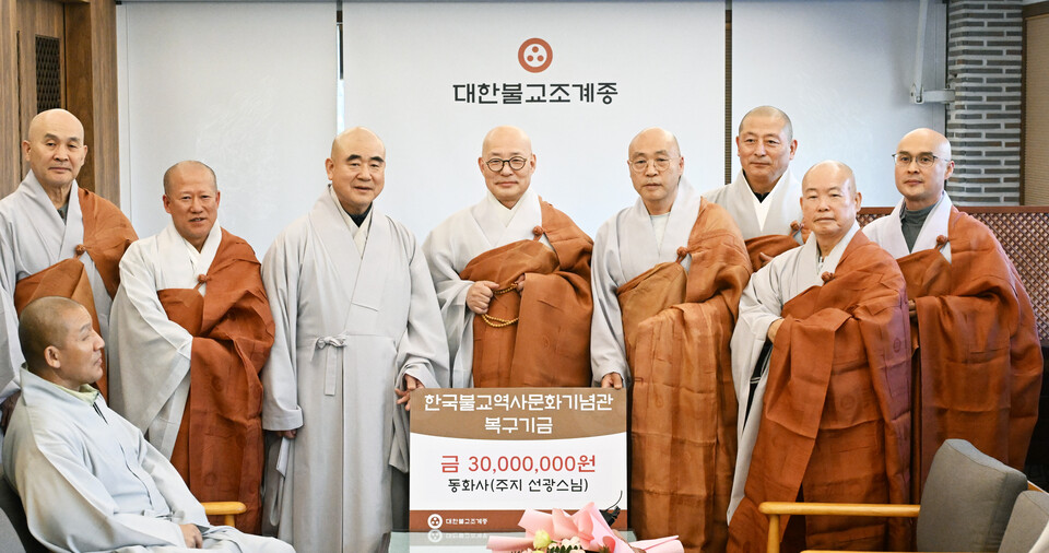총무원장 진우스님(가운데)과 동화사 신임주지 선광스님(오른쪽에서 4번째), 총무원 총무부장 성웅스님(왼쪽에서 3번째) 등과 화재피해 복구기금 전달식을 마친뒤 기념촬영을 하고 있다.