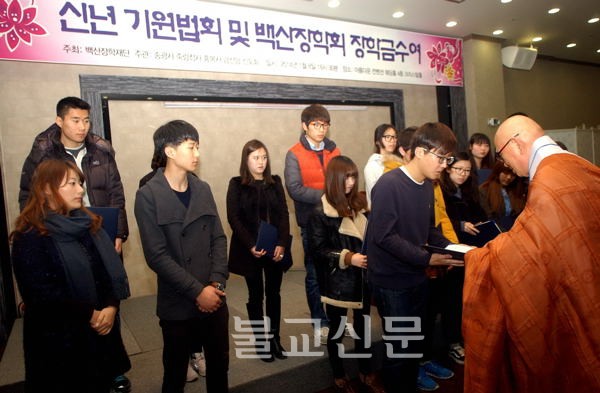 지난 2014년 백신장학재단 이사장 도영스님이 학생들에게 장학금을 전달하며 응원하는 모습.