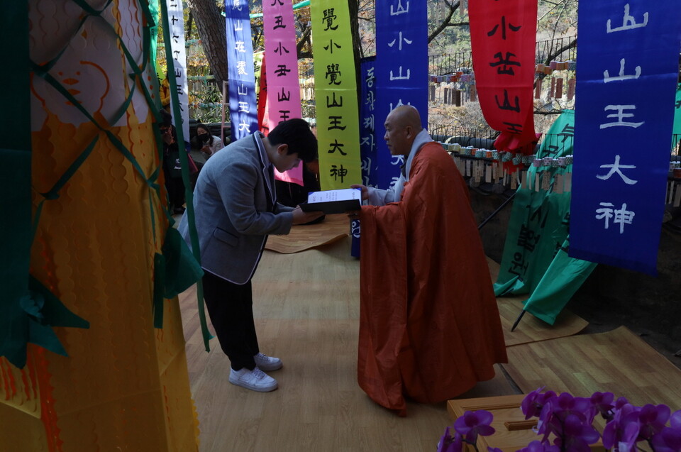 사부대중의 십시일반으로 수여되는 장학금을 성본스님이 전닳하고 있다.