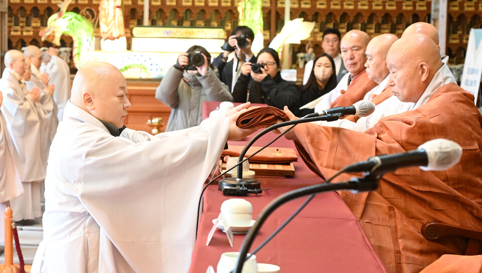  품수자를 대표해 종봉스님이 21조 가사를 받고 있다. 