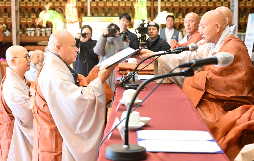  법원스님이 품수자를 대표해 종사 법계증을 받고 있다. 