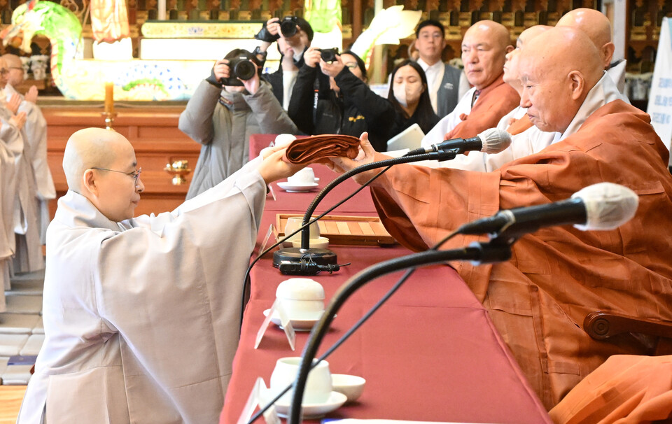 원영스님이 품수자를 대표해 21조 가사를 받고 있다.