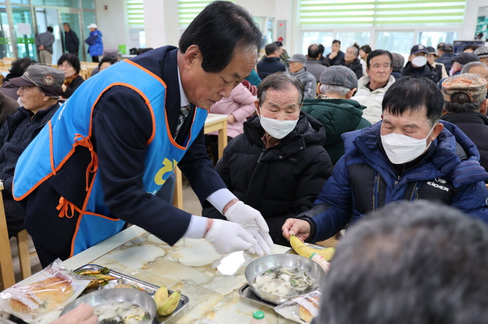 유덕근 고창농협조합장이 떡국을 주민들에게 배달하고 있다