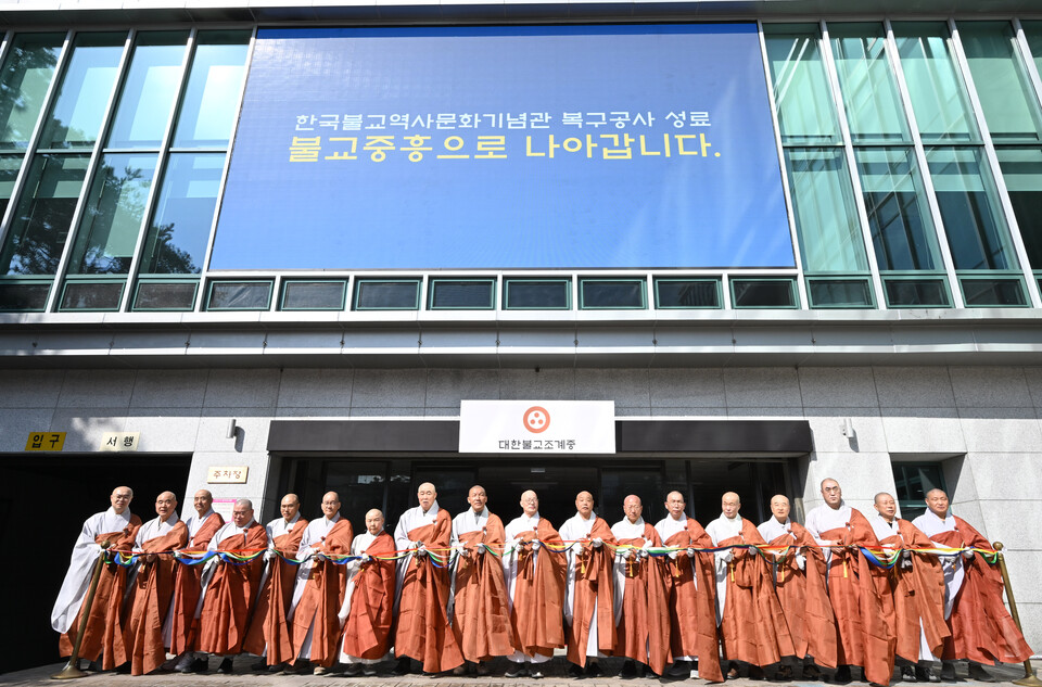 조계종 총무원은 3월31일 한국불교역사문화기념관 1층 앞마당에서 ‘불교중흥으로 나아갑니다’라는 슬로건을 내걸고 기념관 복구공사 성료 기념식을 거행했다. 총무원장 진우스님은 이 자리에서 기념관 복구 성료를 계기로 불교중흥을 향한 새로운 도약을 다짐했다.  최근 공사를 마무리 한 국제회의장 앞에서 찍은 테이프 커팅식 모습. 