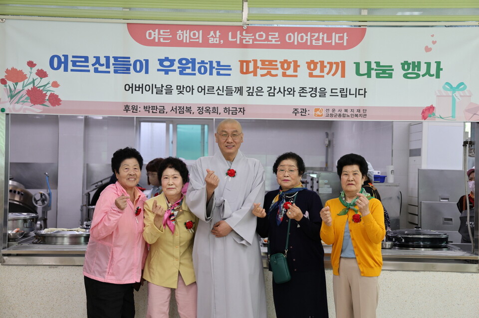 도형 관장스님이 어버이날 나눔행사에 참석한 어르신들과 기념사진을 찍고 있다.
