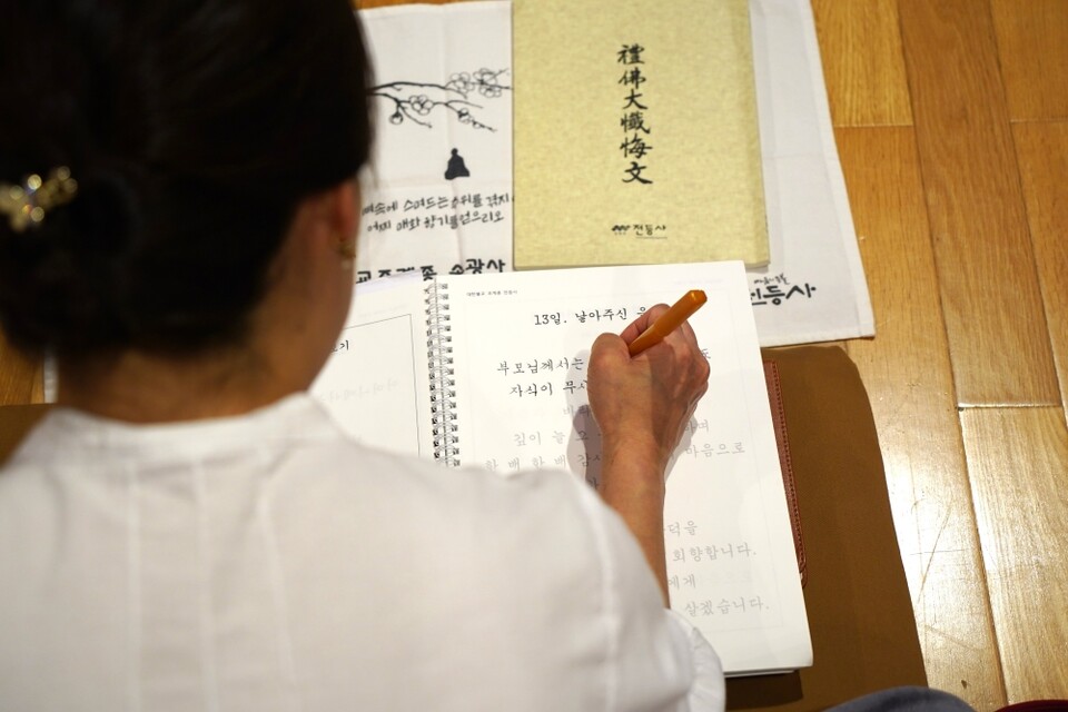 전등사는 백중을 위해 부모은중경 사경집을 특별 제작했다. 사경하고 있는 불자.